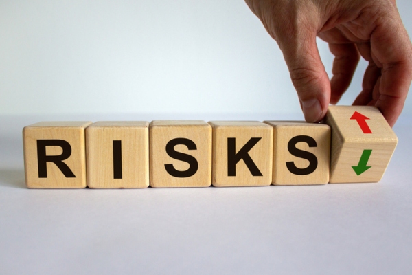 risks word spelled using wooden letter blocks depicting cracked heat exchanger