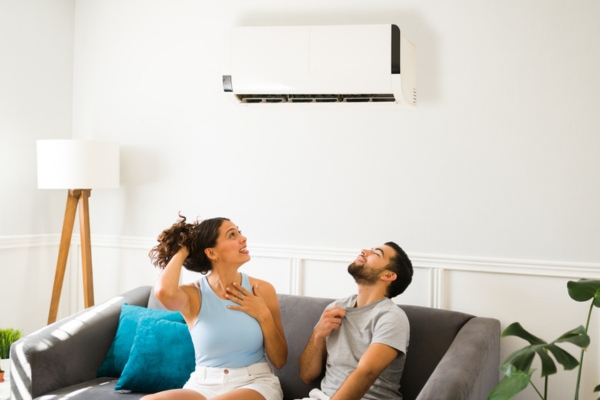 couple feeling warm in front of malfunctioning ductless air conditioner