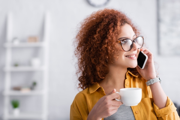 woman holding a cup of coffee while calling for oil delivery